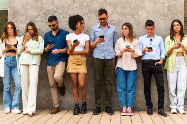 Genç insanlar akıllı telefon grubundan arkadaşlarıyla cep telefonu dijital dokunuşları ve teknoloji kavramları ile sohbet ederek mesajlarını iletiyorlar.