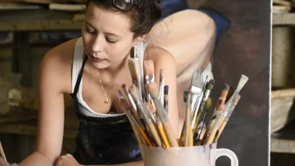 Студент смешивает краску на палитре — стоковое видео