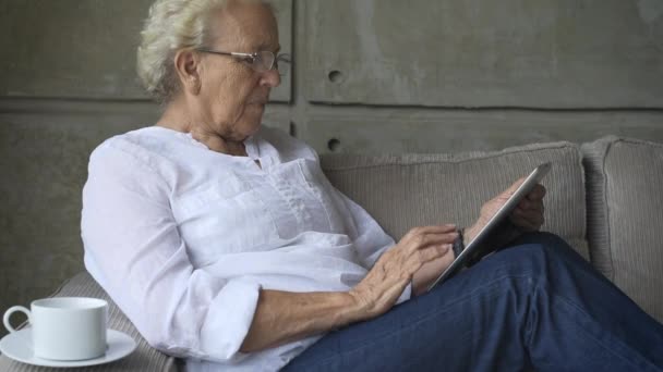 Mormor som arbetar med digitala platta — Stockvideo