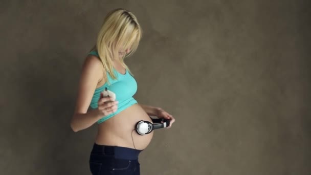 Pregnant woman dancing with headphones — Stock Video