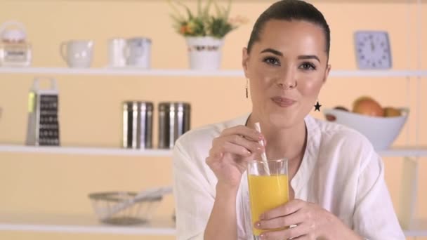 Vrouw die sinaasappelsap drinkt — Stockvideo