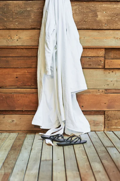 Kleid oder Mantel hängen in einem Wellnessbereich mit Sandalen — Stockfoto