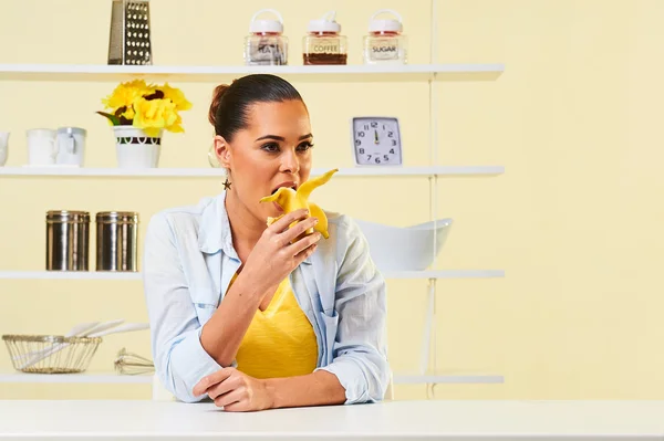 Приваблива жінка дівчина їсть кусаючи банан здорова їжа — стокове фото