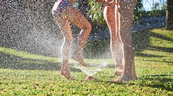 Meninas jogando perto de água aspersor — Fotografia de Stock