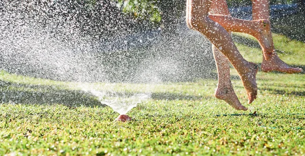 Niñas jugando cerca de aspersor de agua —  Fotos de Stock