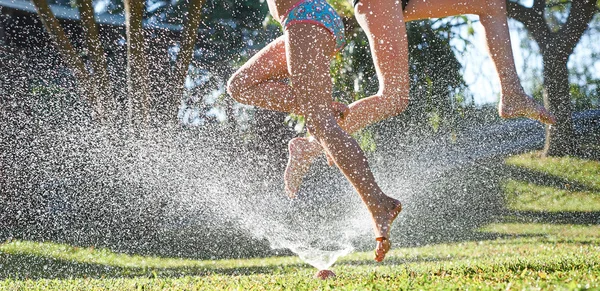 Lányok játszanak közelében a víz sprinkler — Stock Fotó