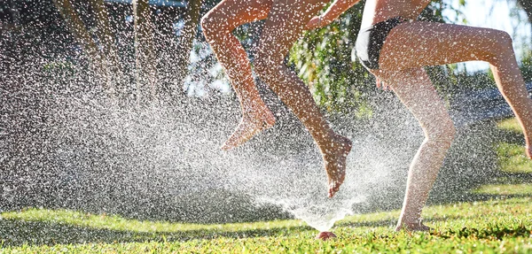 Lányok játszanak közelében a víz sprinkler — Stock Fotó