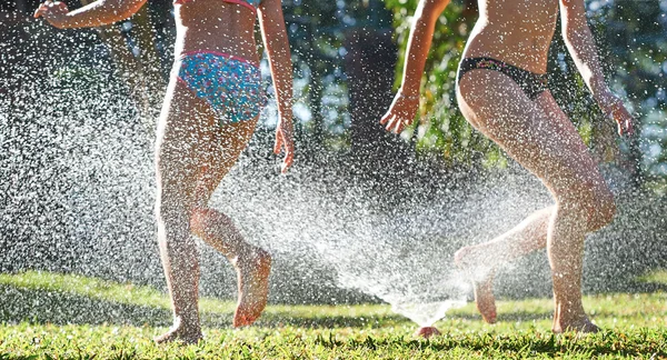 Flickor leker nära vatten sprinkler — Stockfoto