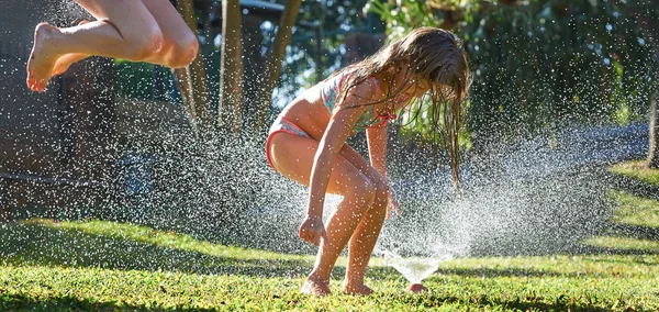 Ragazze che giocano vicino spruzzatore d'acqua — Foto Stock