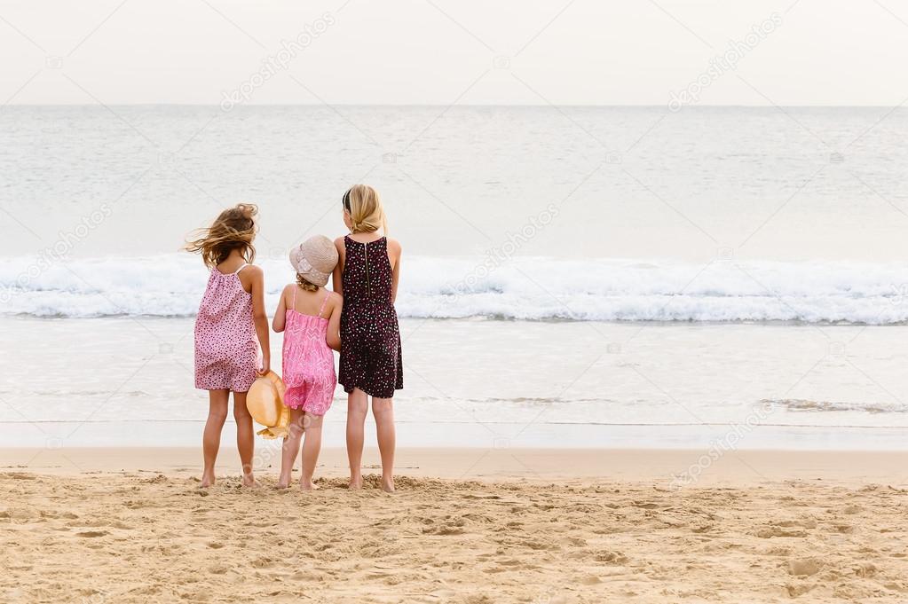 sisters standing on sea shore