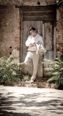 Rustik bir kapıya yaslanmış adam