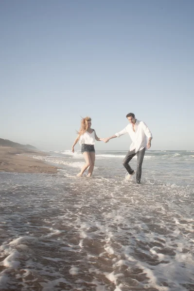 Paar geht am Strand spazieren — Stockfoto