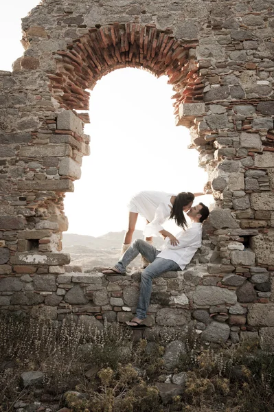 Paar küsst sich in Steinbogen — Stockfoto