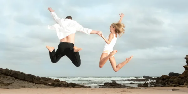 Couple sautant sur la plage — Photo