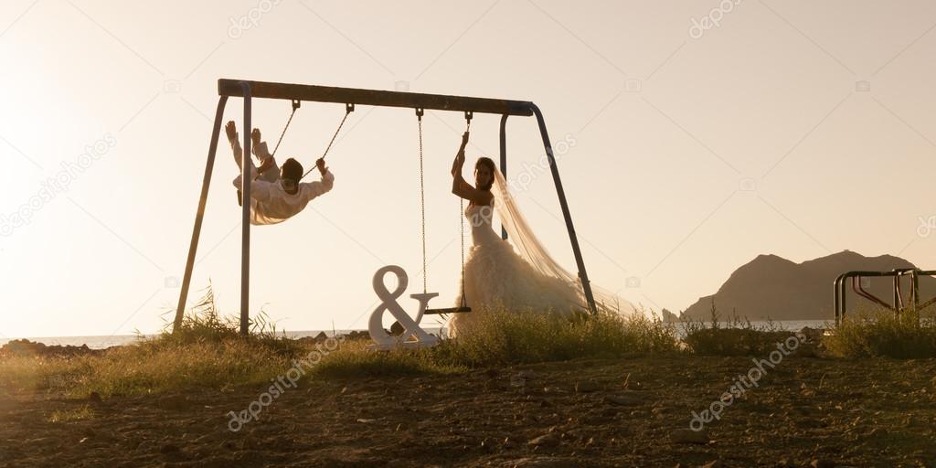 Newlywed couple on swings