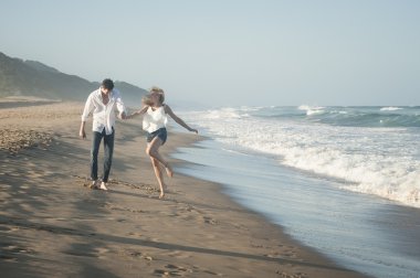 Kumsalda yürüyen çift. 