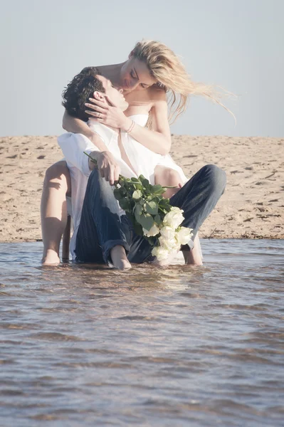 Pareja besándose en la playa — Foto de Stock