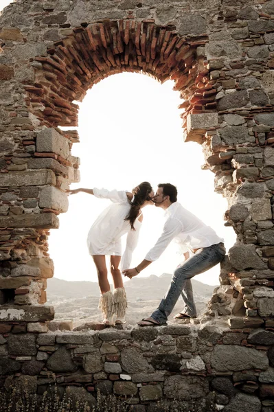 Couple kissing in stones archway — Stock Photo, Image