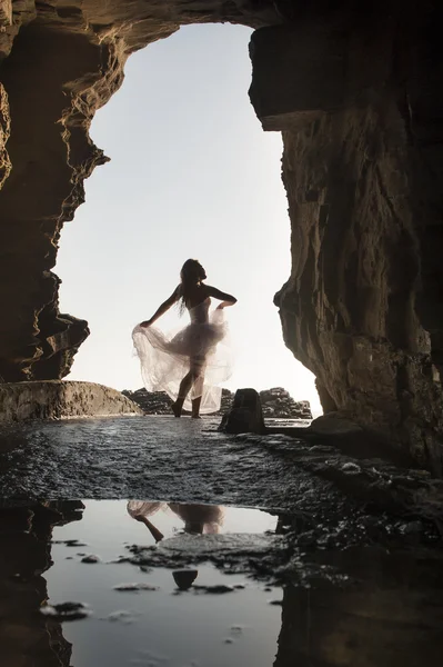 Femme dansant sous une arche rocheuse — Photo