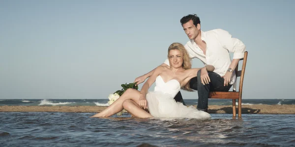 Paret sitter på stranden — Stockfoto