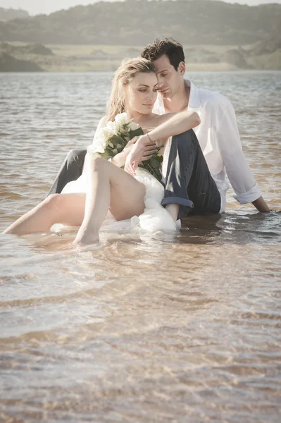 Couple assis sur la plage — Photo