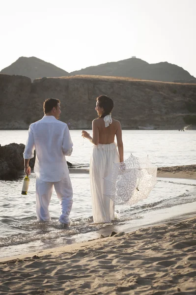 Sposa e sposo a piedi al mare — Foto Stock