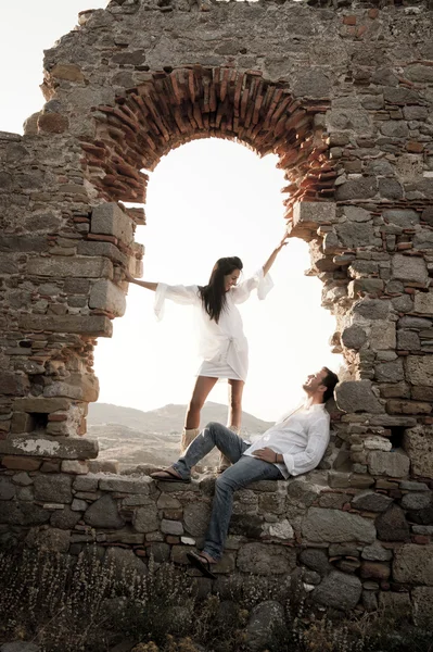 Couple under stone archway — Stock Photo, Image