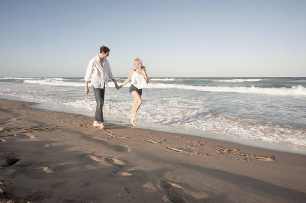 Paar geht am Strand spazieren — Stockfoto