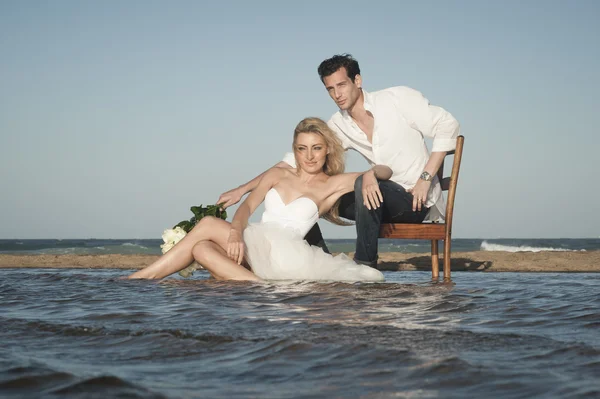 Pareja sentada en la playa — Foto de Stock