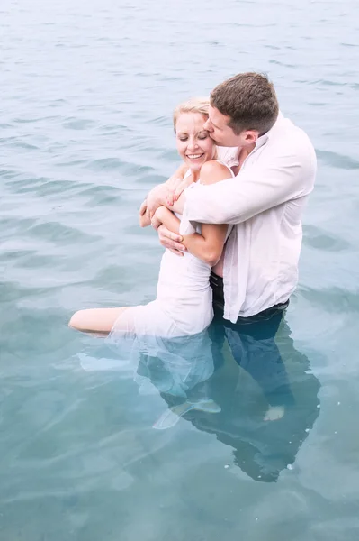 Pareja joven parada en el agua — Foto de Stock