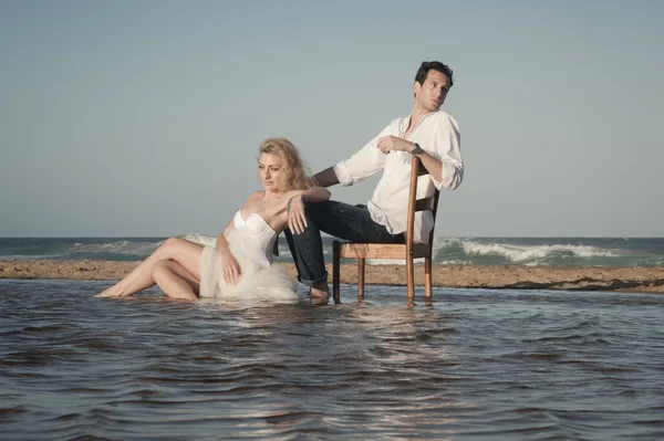 Paar sitzt am Strand — Stockfoto