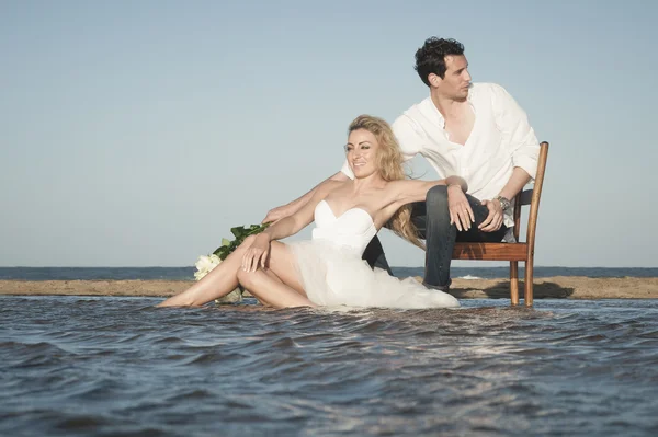 Couple assis sur la plage — Photo