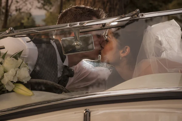 Newlywed para Całowanie w zabytkowych samochodów — Zdjęcie stockowe