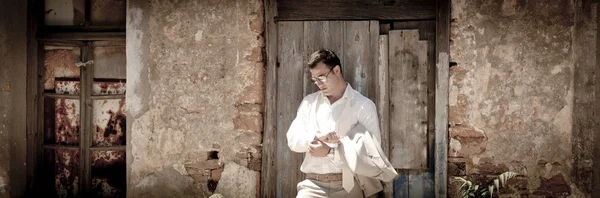 Man leaning against a rustic door — Stock Photo, Image