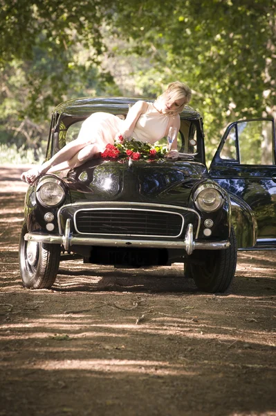 Hermosa novia en coche vintage — Foto de Stock