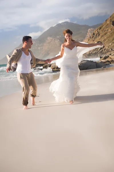 Menyasszony és a vőlegény a tengerparton fut — Stock Fotó