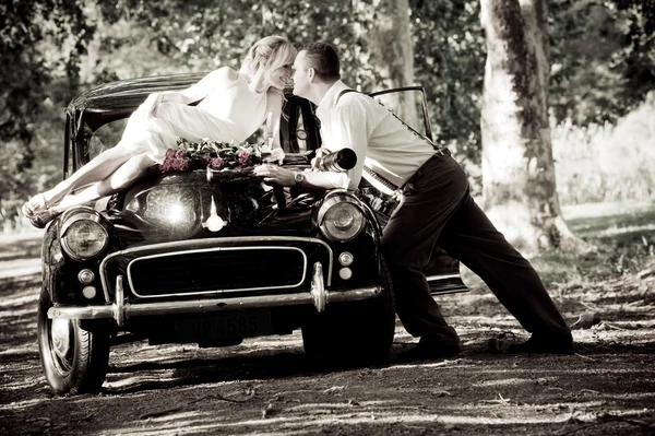 Newlywed couple with vintage car — Stock Photo, Image