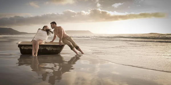 Par på stranden med gamla badkar — Stockfoto