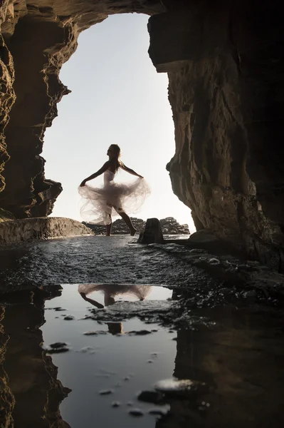 Vrouw dansen onder rotsachtige archway — Stockfoto