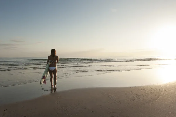 Frau im Bikini trägt Surfbrett — Stockfoto