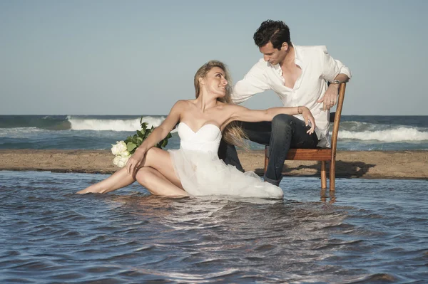 Couple assis sur la plage — Photo