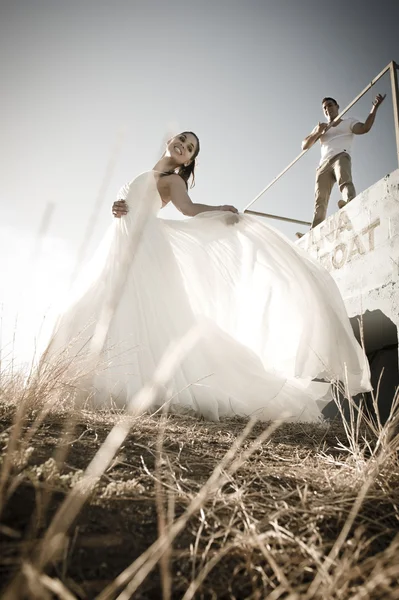 Femme en robe de mariée sur herbe jaune — Photo