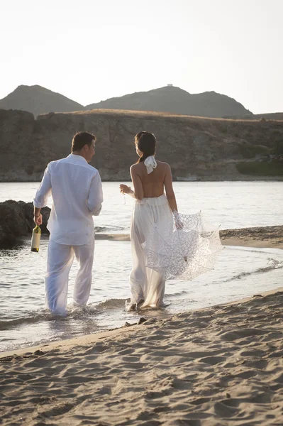 Sposa e sposo a piedi al mare — Foto Stock