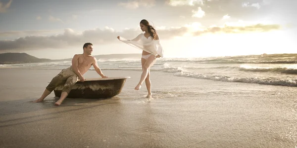 Par på stranden med gamla badkar — Stockfoto