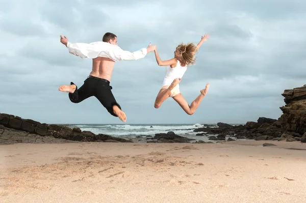 Casal pulando na praia — Fotografia de Stock