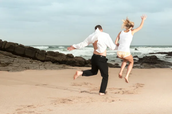 Paar springt am Strand — Stockfoto