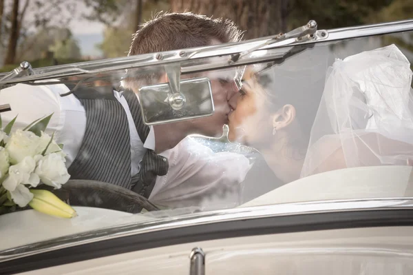 Молодая пара целуется в винтажной машине — стоковое фото