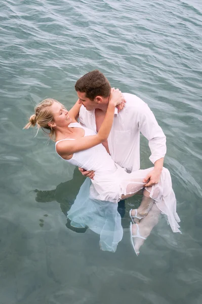 Pareja joven parada en el agua — Foto de Stock