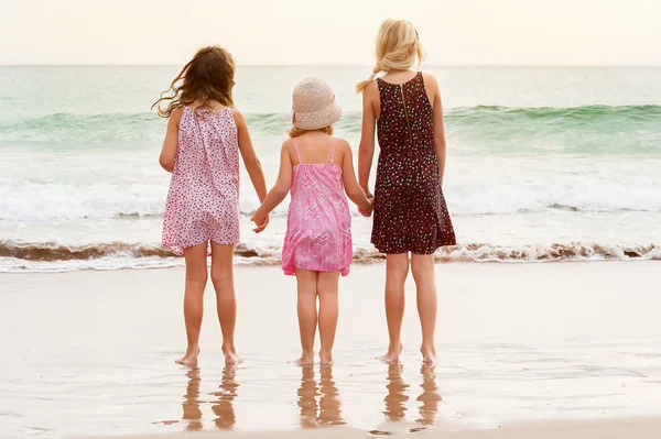 Sisters standing on sea shore — Stock Photo, Image