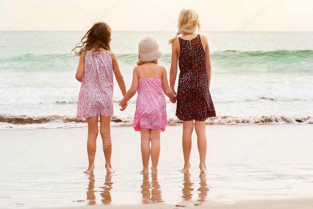 sisters standing on sea shore